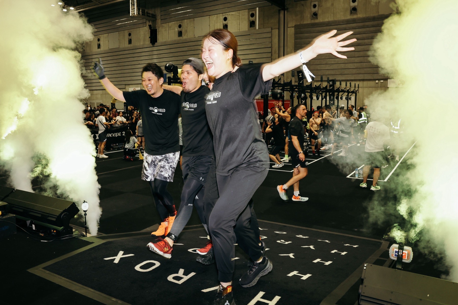 スモークが焚かれたHYROXイベントで跳ぶGYM FIELDのメンバー